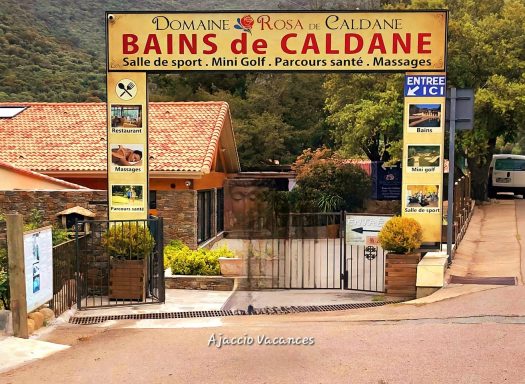 Entrée des Bains de Caldane avec panneaux d'information et végétation environnante.